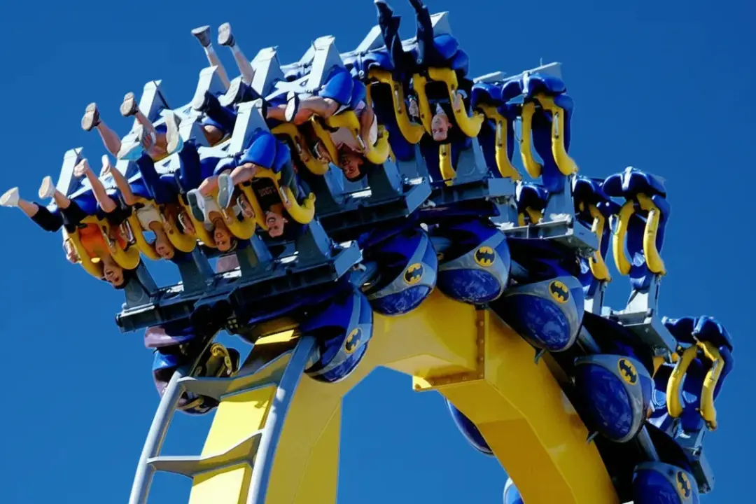 Personas disfrutando de Batman Arkham Asylum, una de las mejores atracciones Warner Madrid, durante un giro invertido.